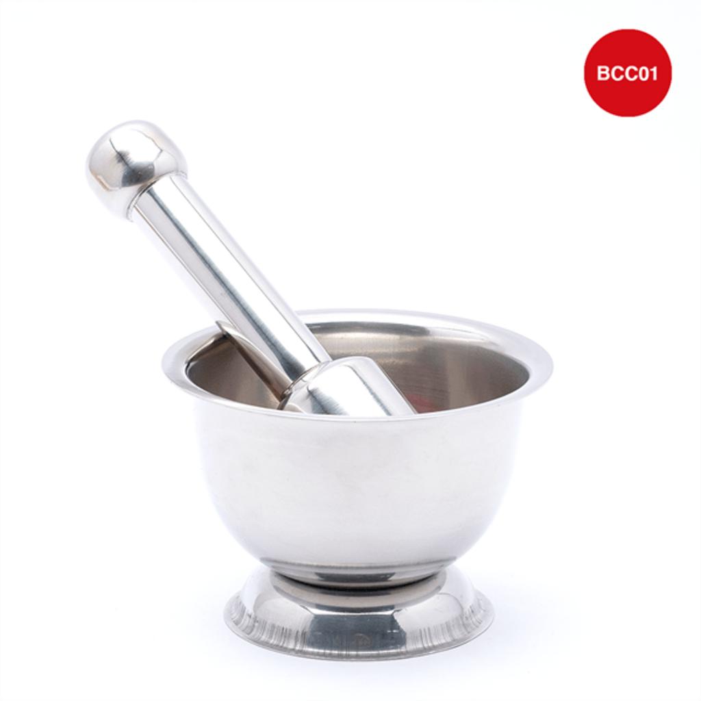 hands using stainless steel mortar and pestle grinding spices in kitchen