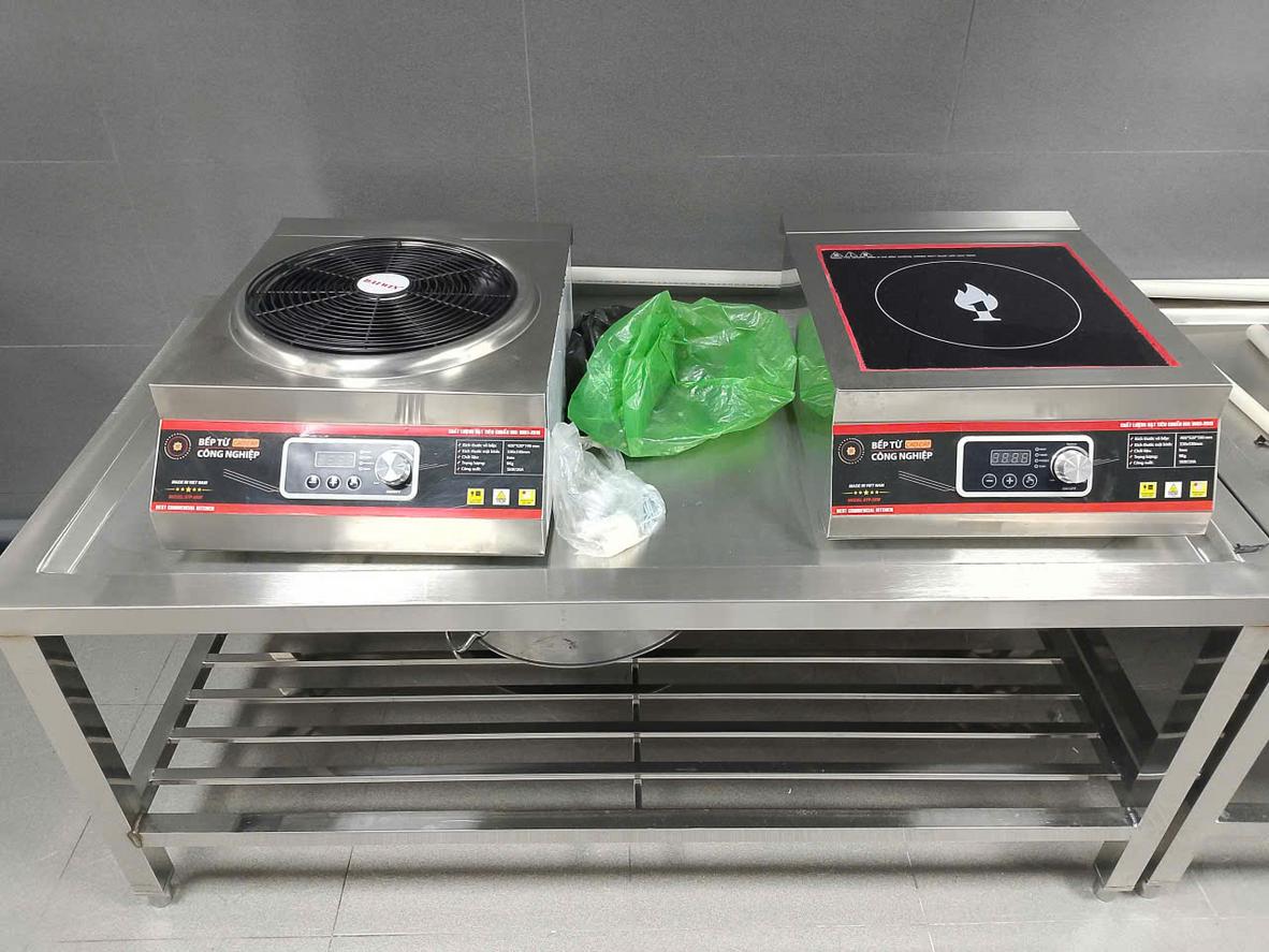 Nhân viên bếp thực hiện quy trình vệ sinh bàn soạn chia inox cuối ngày.