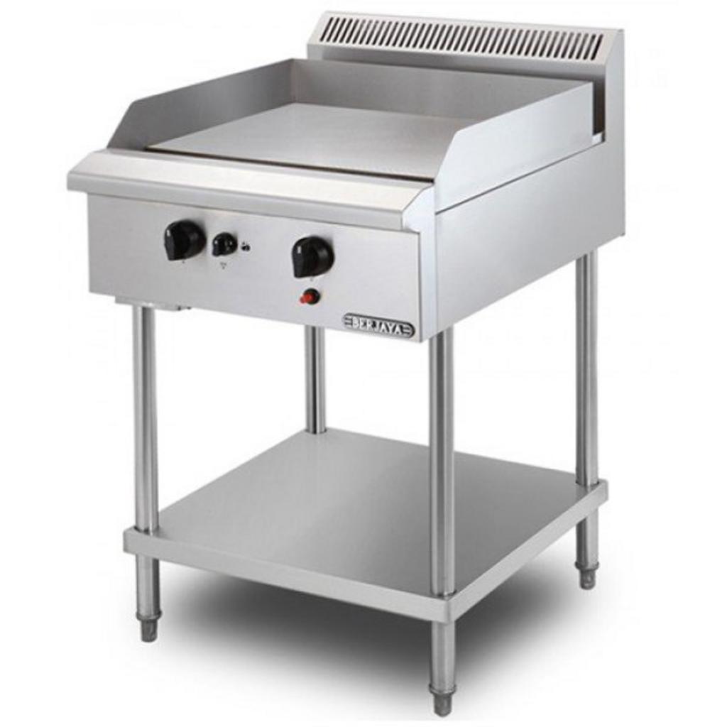 Kỹ thuật viên đang kiểm tra hệ thống gas và ống hút mùi sau khi lắp đặt bếp chiên phẳng.