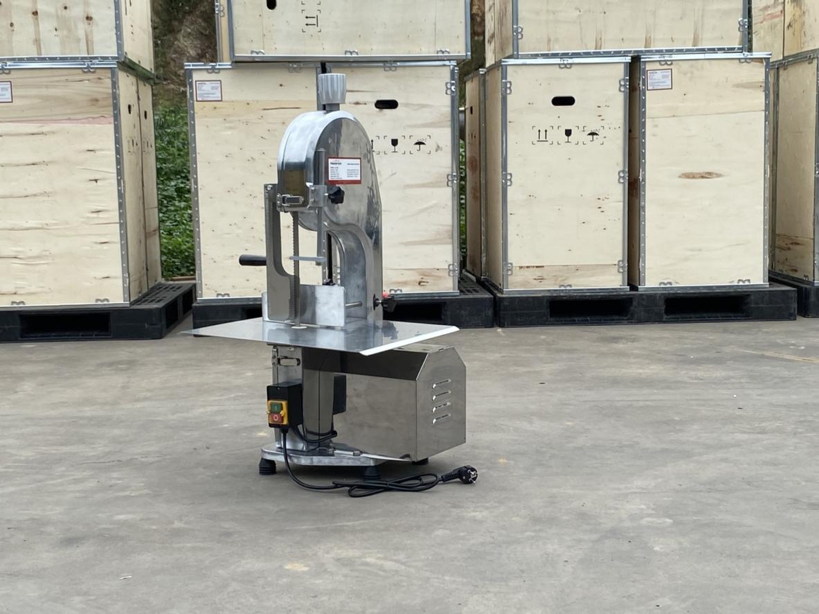 Hình ảnh tổng quan máy cưa xương công nghiệp đang vận hành trong bếp ăn.