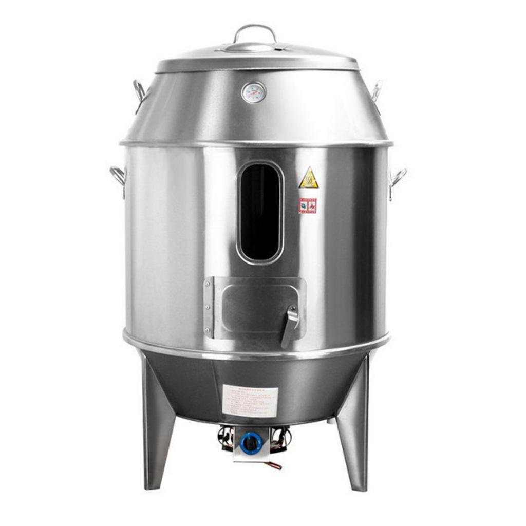 Một chiếc lò quay vịt inox đang hoạt động trong bếp nhà hàng, cho thấy vịt quay vàng óng hấp dẫn.