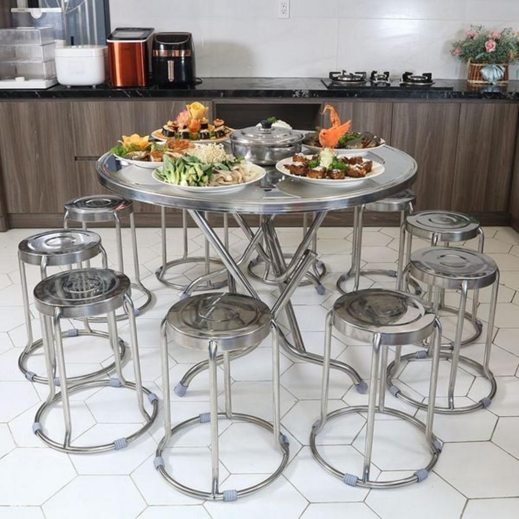 Bộ bàn ghế inox được sắp xếp ngay ngắn trong một nhà ăn tập thể.