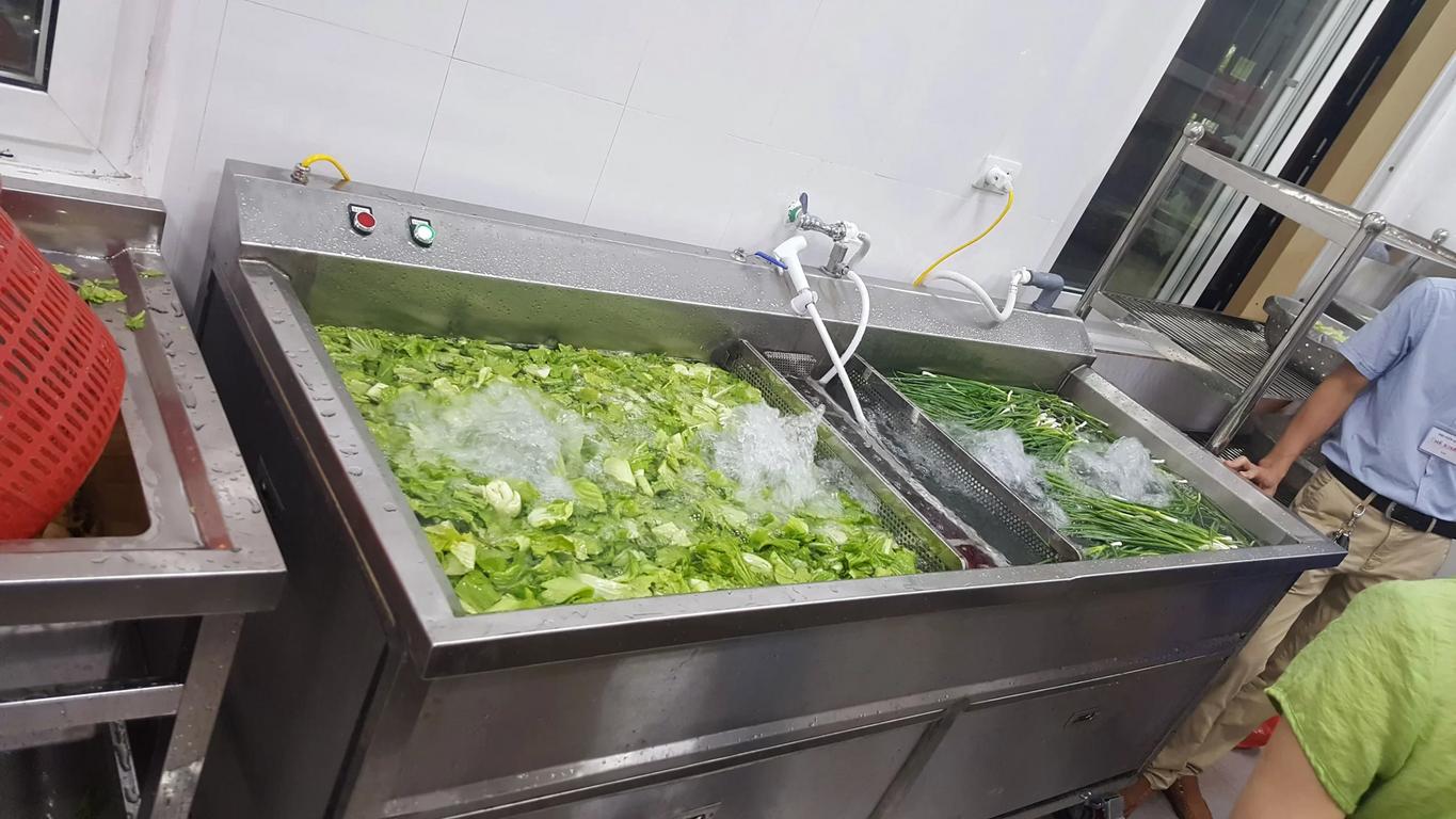 Kỹ thuật viên đang hướng dẫn khách hàng cách điều chỉnh độ dày lát cắt và vận hành máy an toàn.