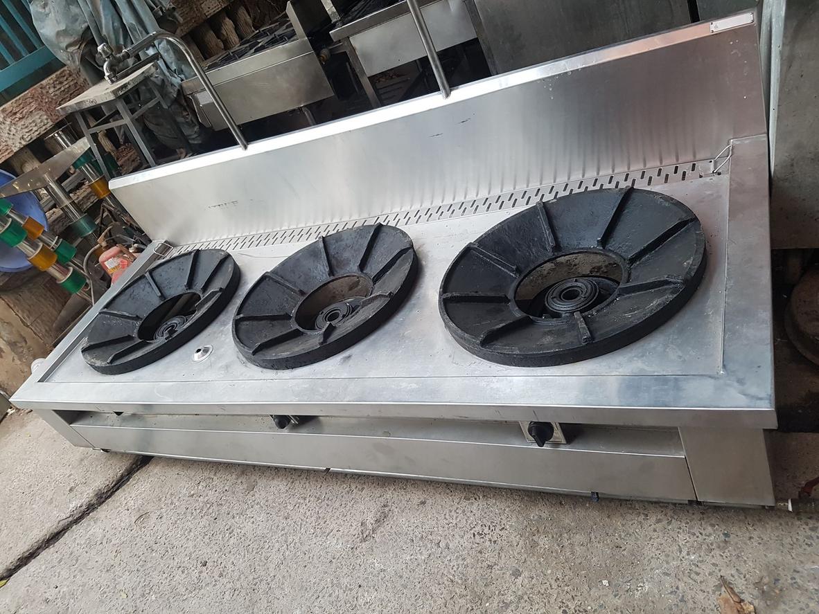 Nhân viên bếp đang thực hiện kiểm tra van gas trước khi khởi động bếp hầm.