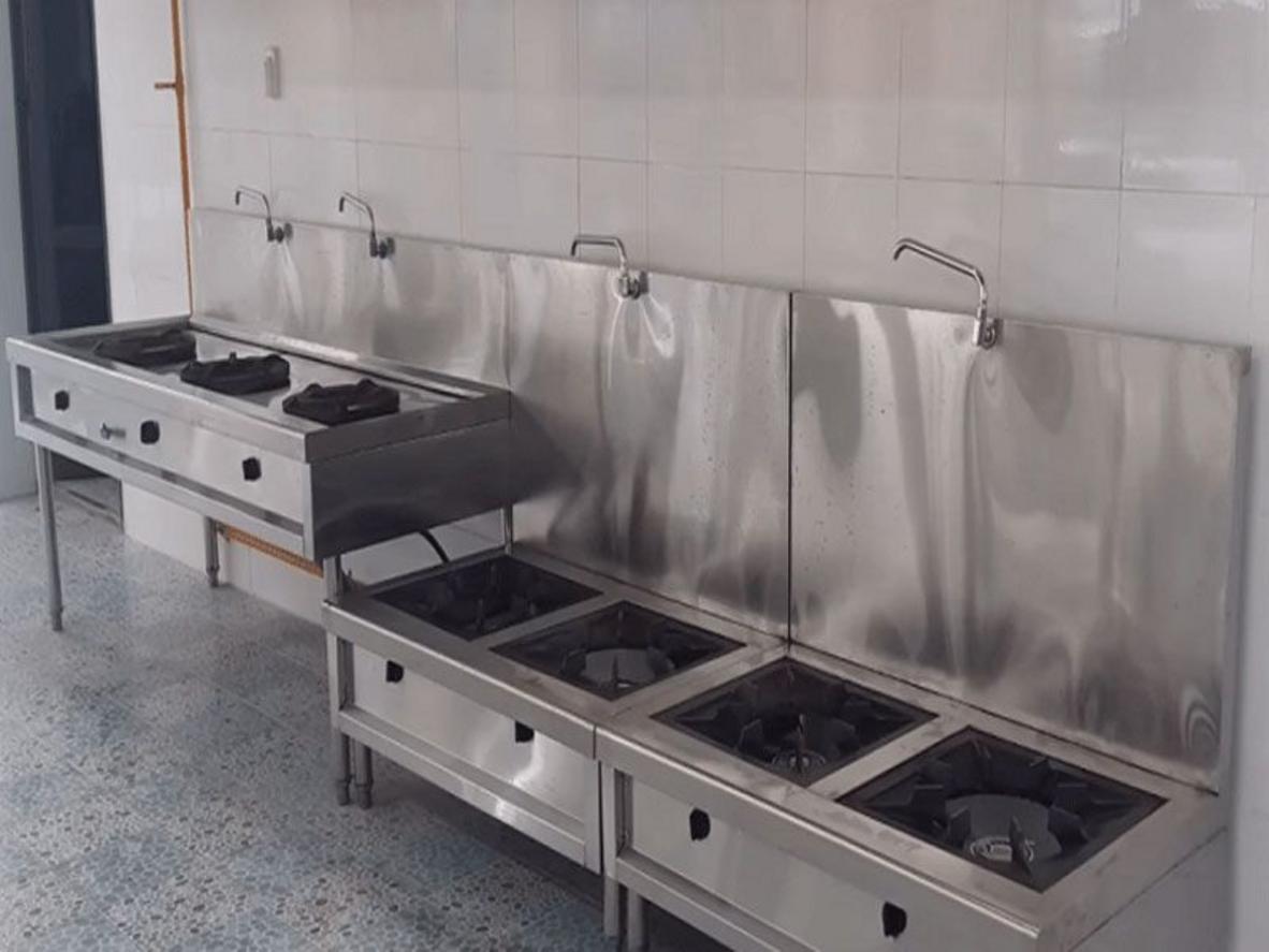 Nhân viên đang vệ sinh kiềng và họng đốt của bếp hầm công nghiệp.