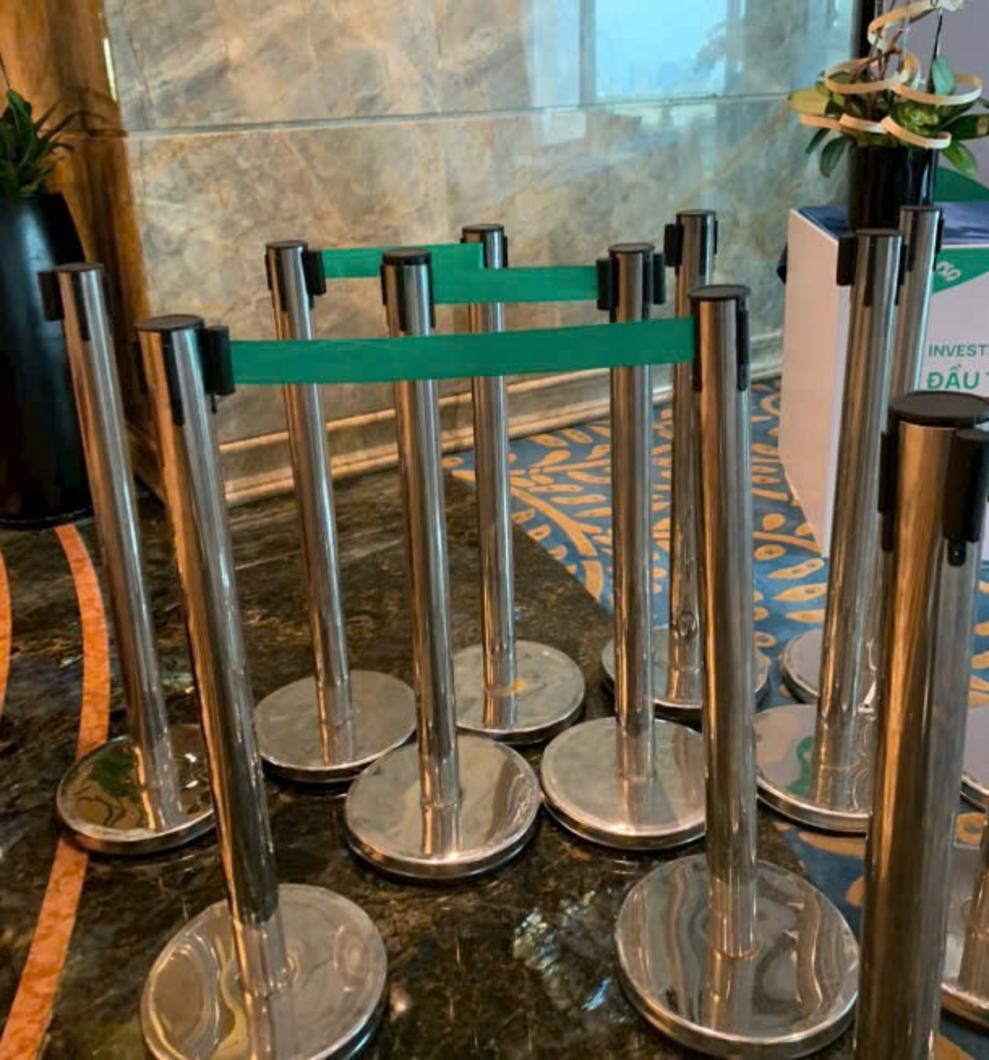 Nhân viên đang vệ sinh cột chắn inox bằng khăn mềm để giữ độ sáng bóng.