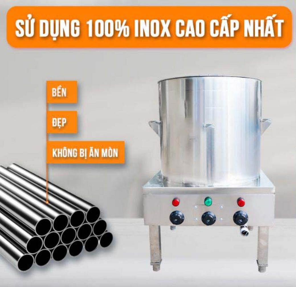 Nhân viên đang thực hiện vệ sinh nồi nấu cháo bằng vòi xịt và dụng cụ chuyên dụng.