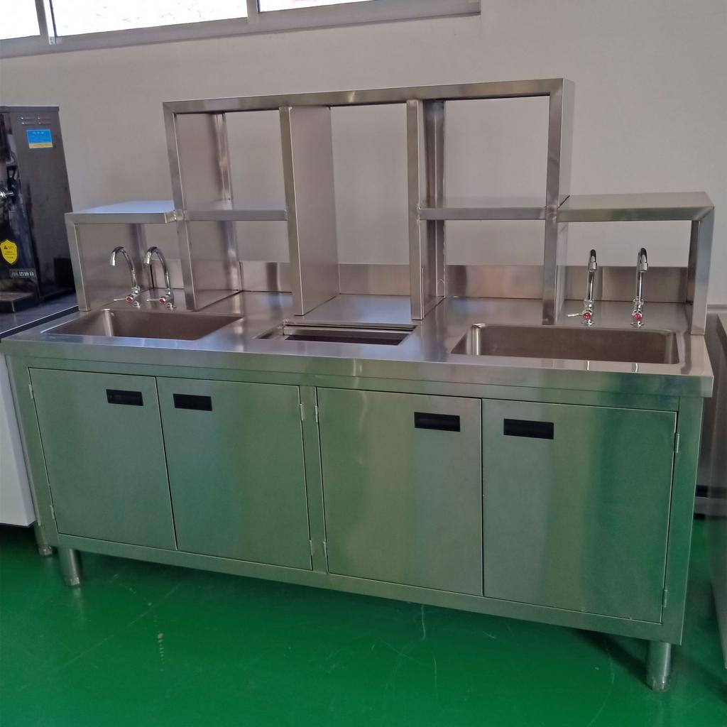 Nhân viên đang vệ sinh quầy pha chế inox bằng khăn mềm và dung dịch chuyên dụng.