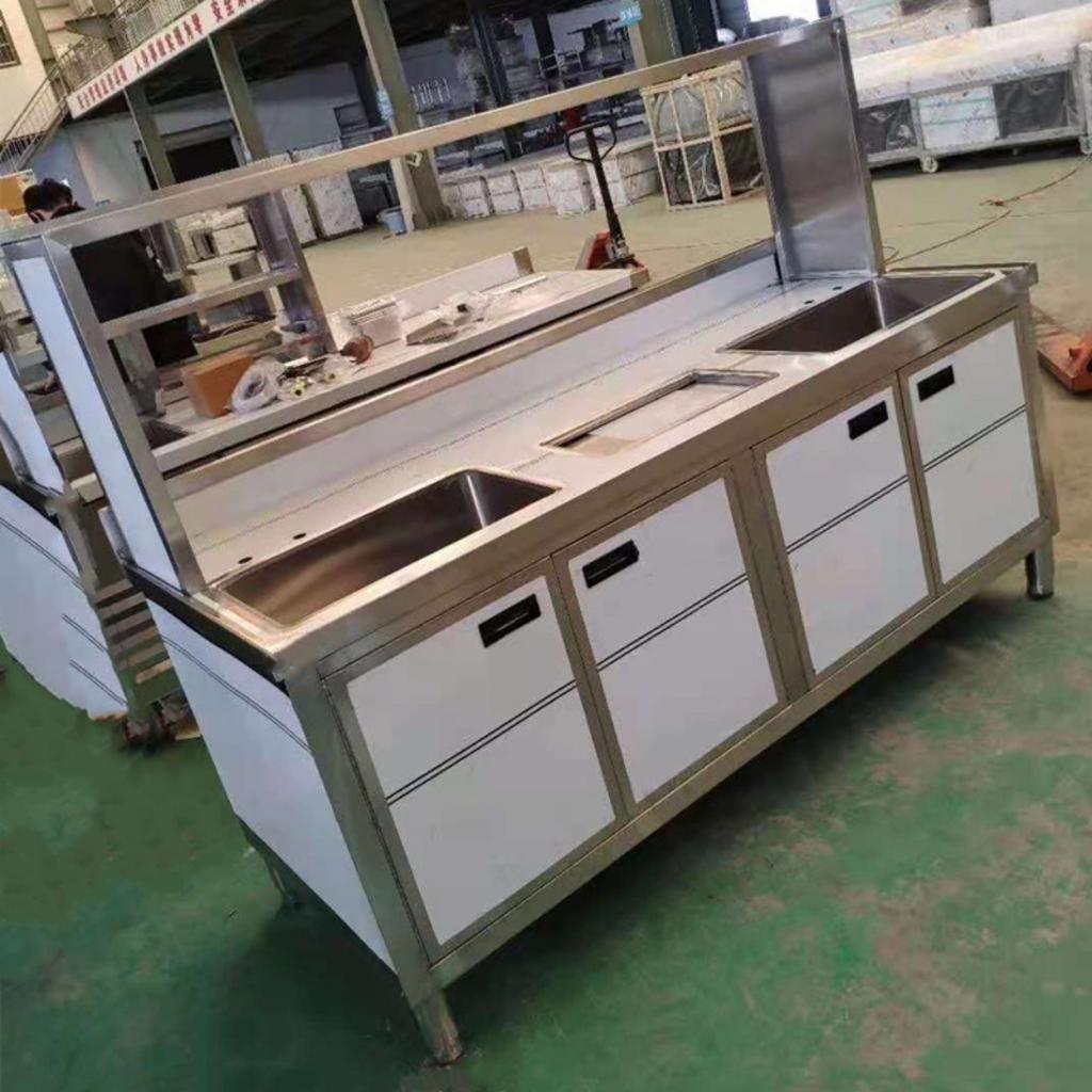 Một mẫu quầy bar có cạnh bo cong mềm mại, kết hợp giữa inox và gỗ, thể hiện xu hướng thiết kế mới.